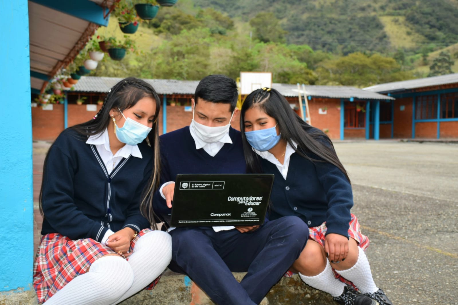 Image: Estudiantes compartiendo un dispositivo digital.