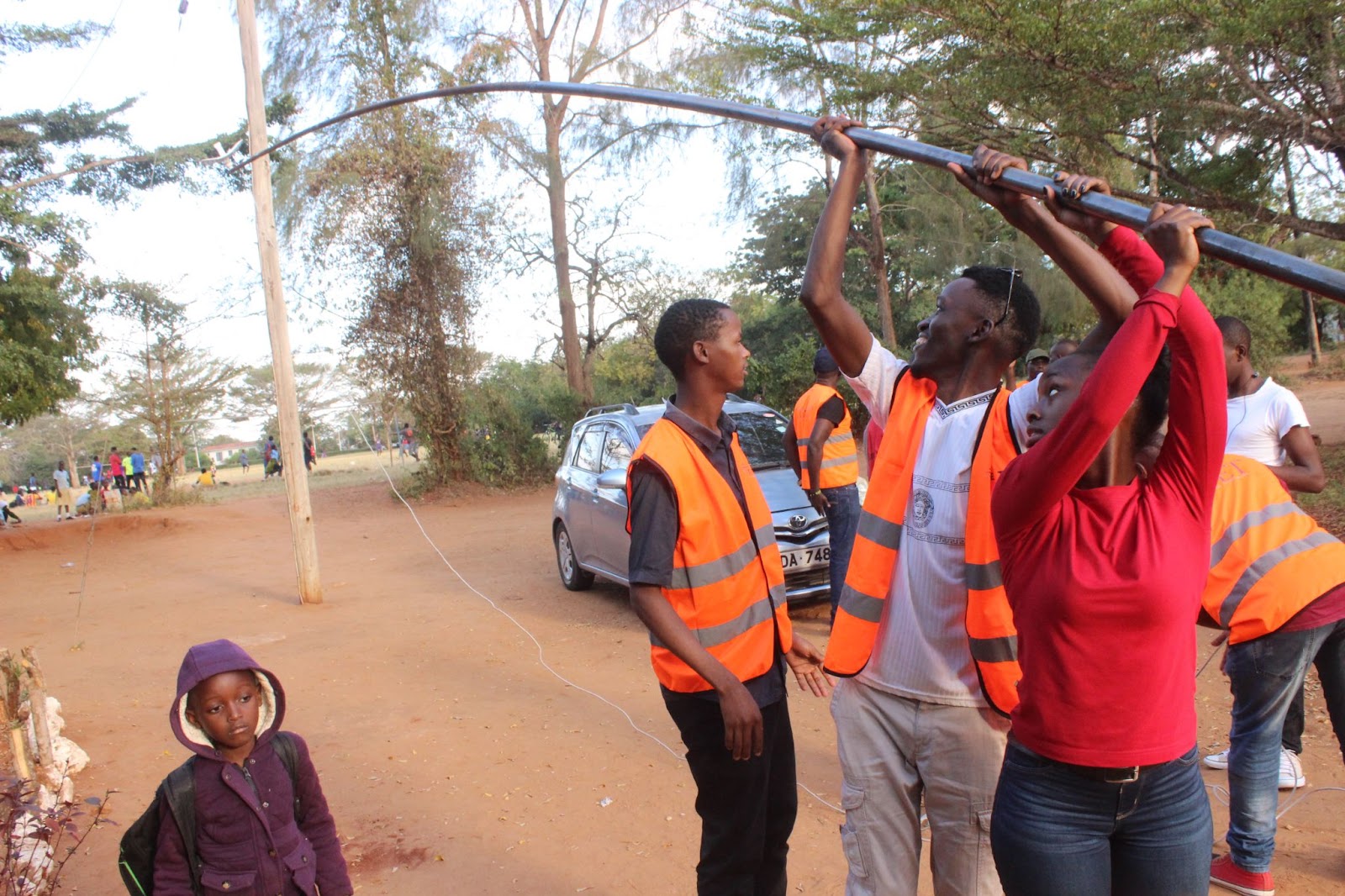 People lift a Wi-Fi antenna during an activity developed by TandaNet in Kenya