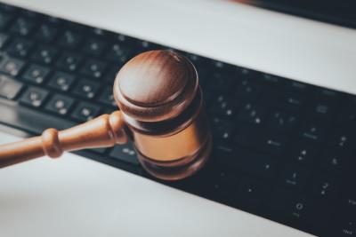 Cover image: Photo of a wooden gavel sitting on top of a computer keyboard by Sasun Bughdaryan. image linking to Full disclosure: Marking a legal victory for big tech transparency in South Korea
